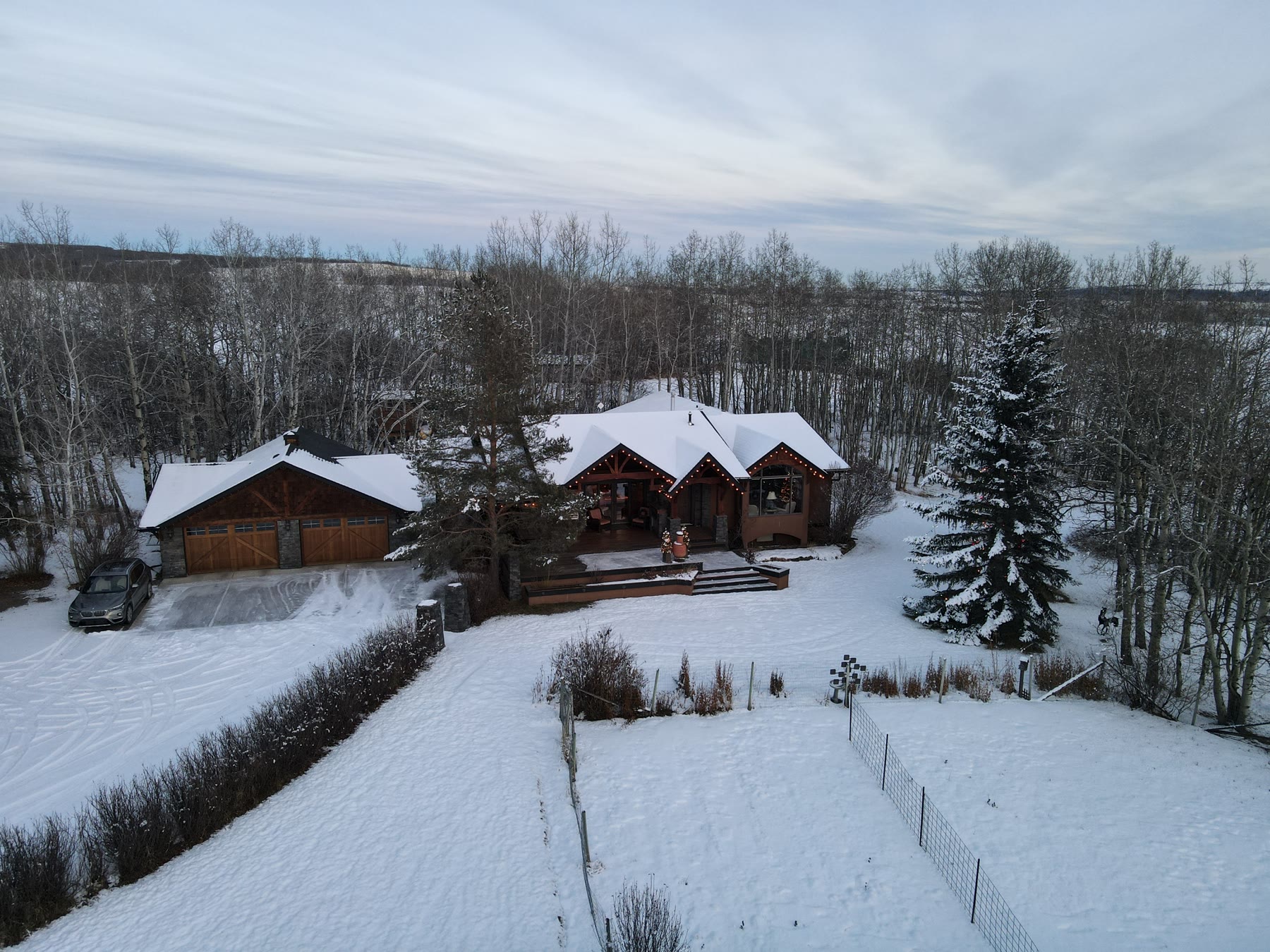 Log home in snow at night, lights on