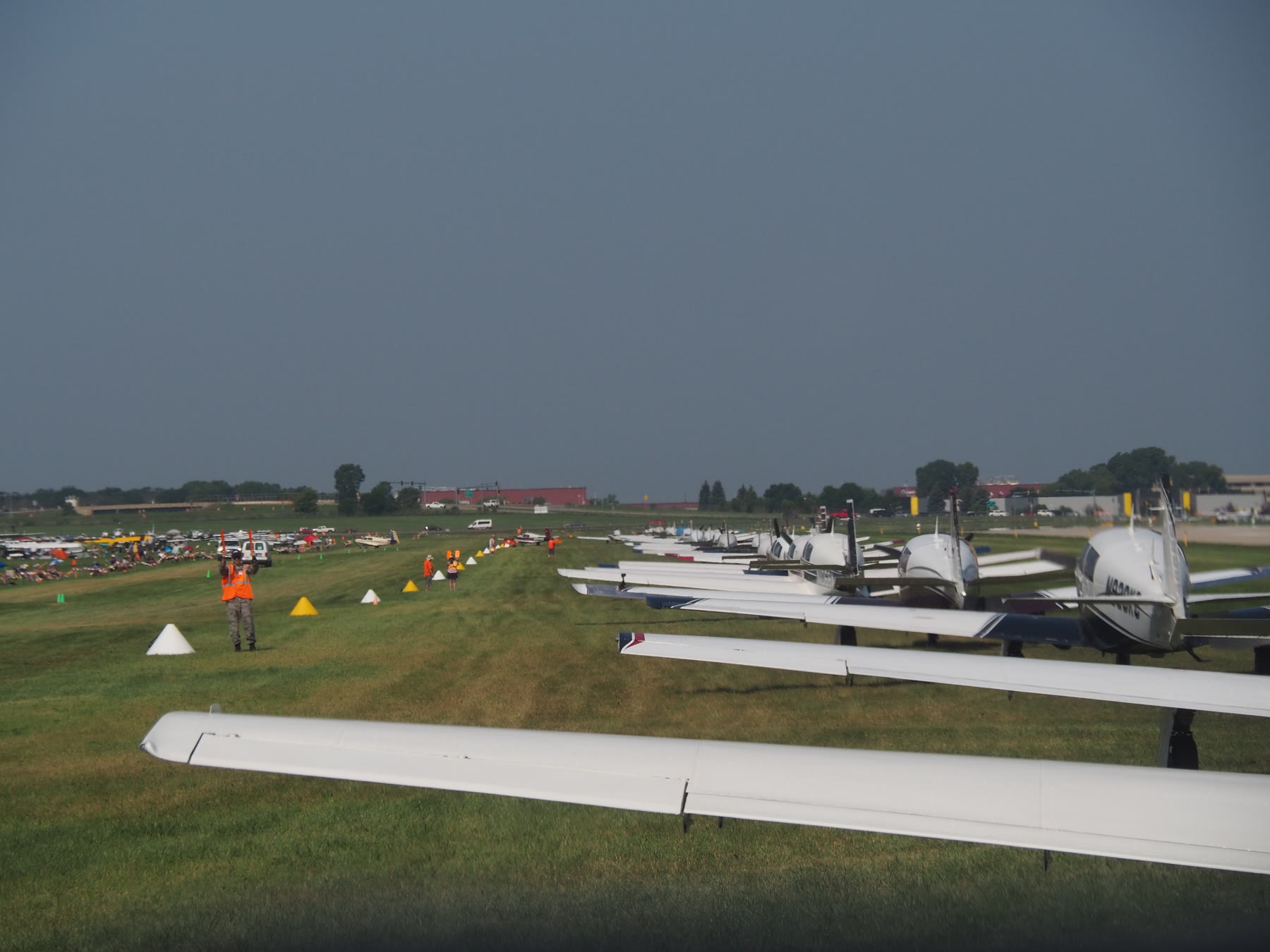 Mooney Caravan aircraft parked in a row on the Oshkosh grass
