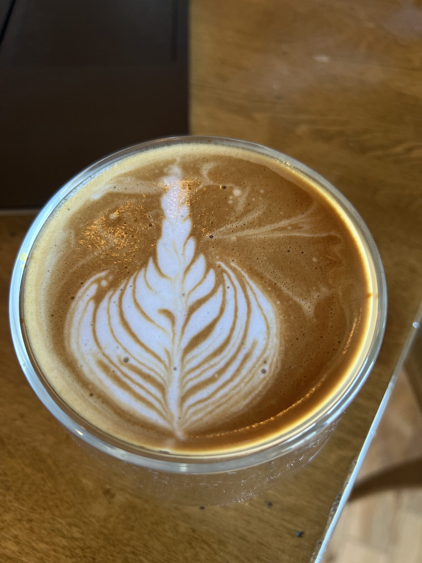 Rosetta in a clear glass cup on a wood table.