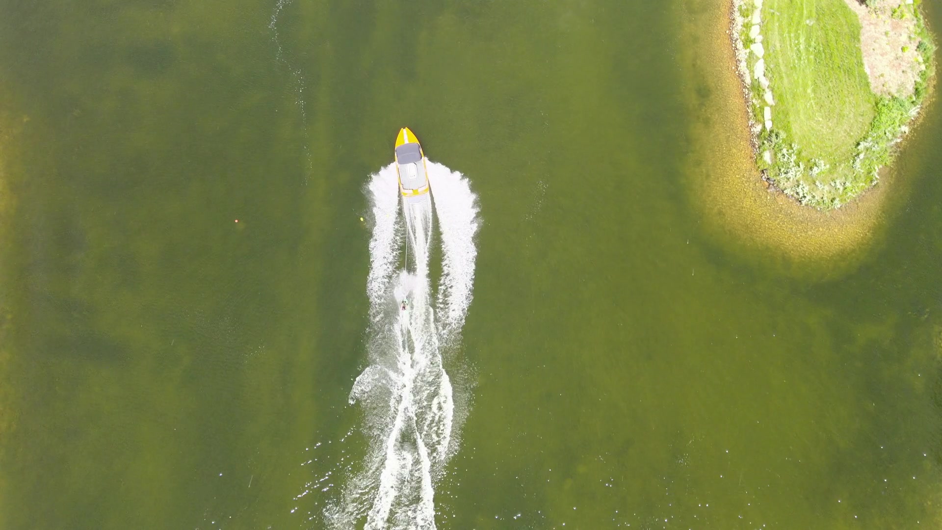 Boat from above, no skier — wake on flat water