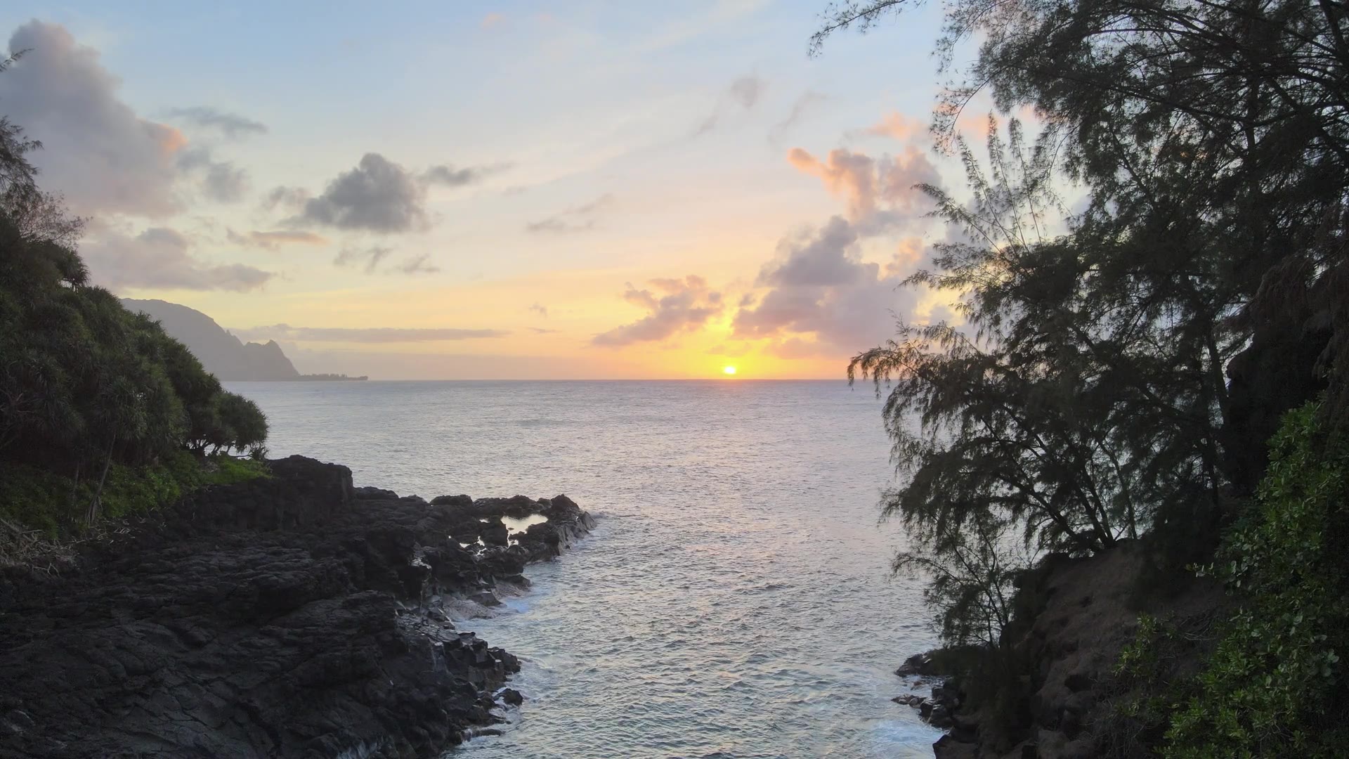 Sunset waves rolling onto a Kauai beach